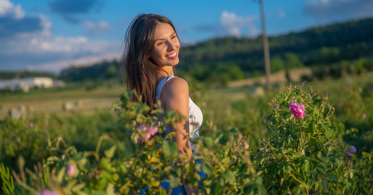 Frau in einem blühenden Rosenfeld im bulgarischen Rosental