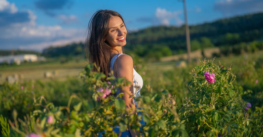 Frau in einem blühenden Rosenfeld im bulgarischen Rosental